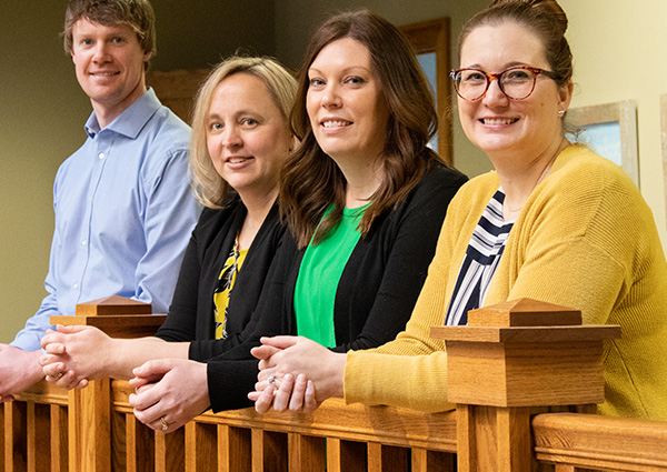 Bank employees John, Erin, Holly, and Mel